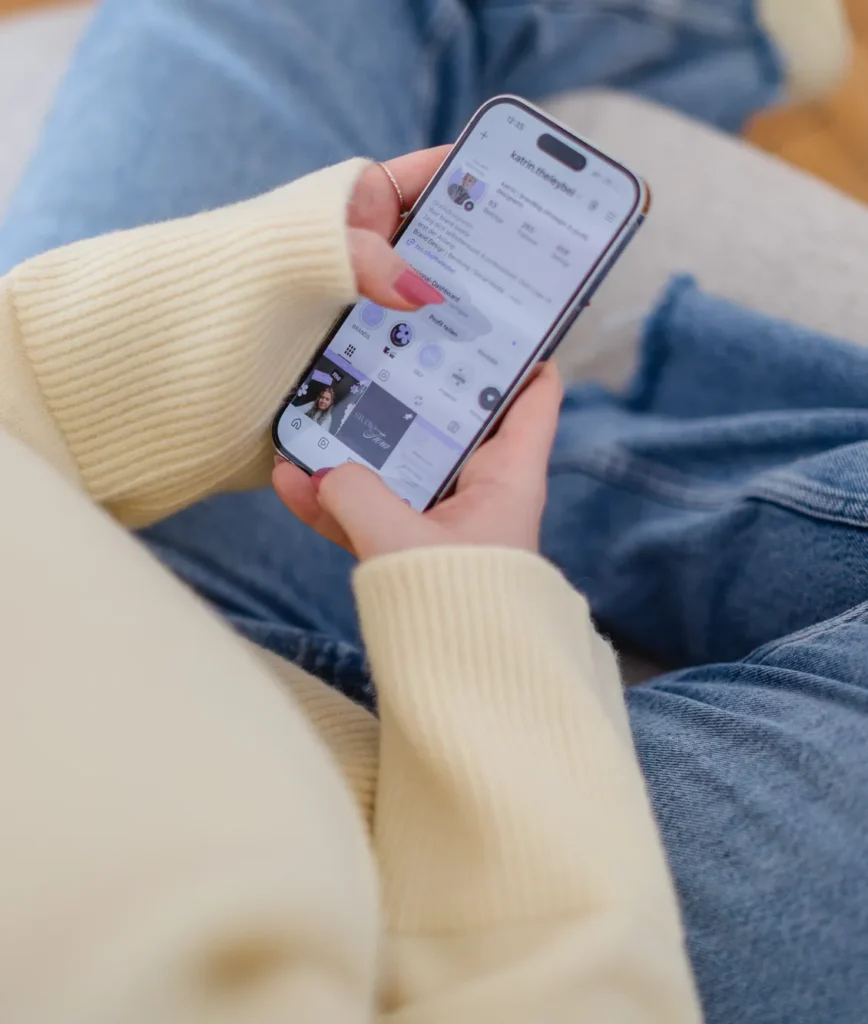 Katrin verwaltet Social-Media-Inhalte auf ihrem Smartphone und überprüft ihr Instagram-Profil