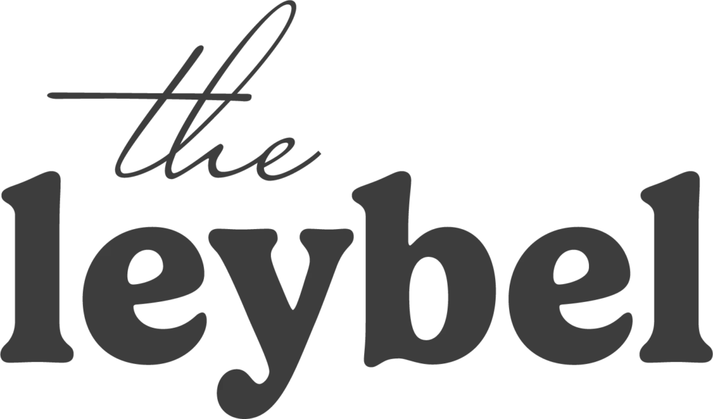 Logo von theleybel mit einer Kombination aus eleganter Handschrift und markanter Serifenschrift. Das Design verbindet Persönlichkeit, Vertrauen und Professionalität zu einer modernen Markenidentität.