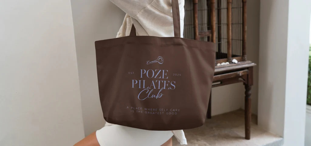 Hochwertige Tragetasche mit individuellem Branding für Poze Pilates Club als Teil einer exklusiven Merchandise- und Markenstrategie für ein modernes Pilates-Studio